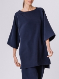 Vista dettaglio della maxi blusa in tessuto di neoprene ultralight con scollo rotondo a barchetta, e maniche a kimono lunghe al gomito. Corpo molto ampio. Lunghezza asimmetrica con spacchi laterali.