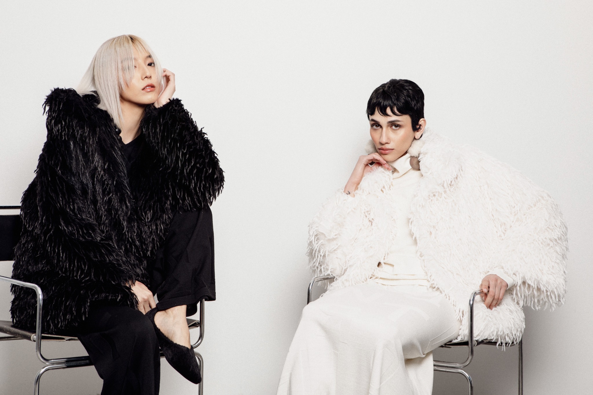 Two models wearing black and white outerwear