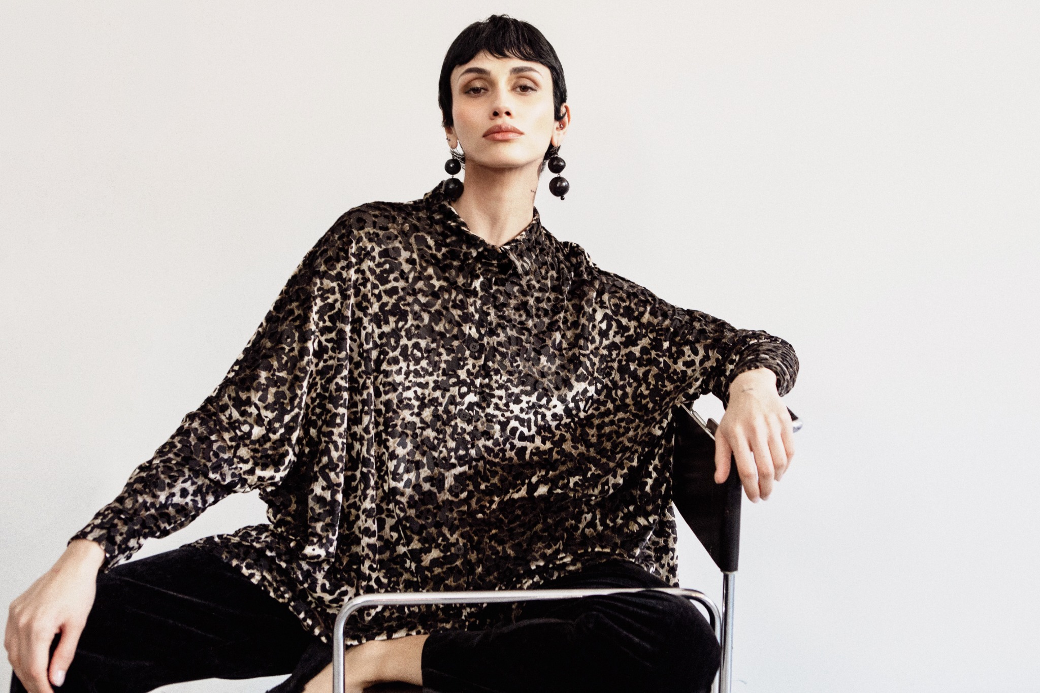 Model wearing an animalier shirt and black trousers