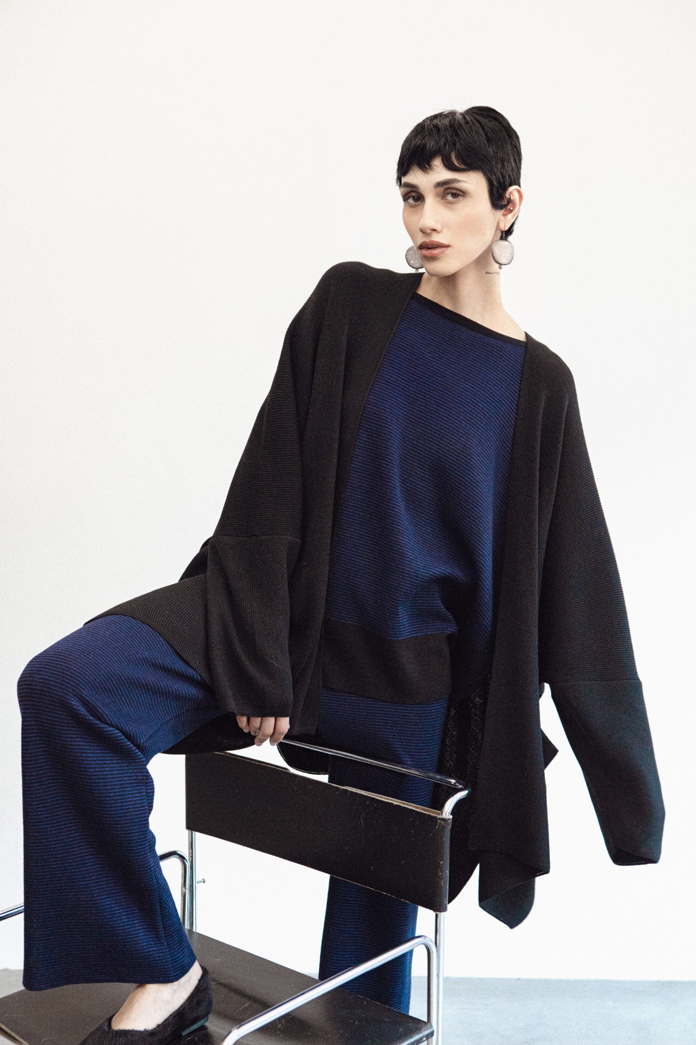 Model in blue and black suit with oversized cardigan